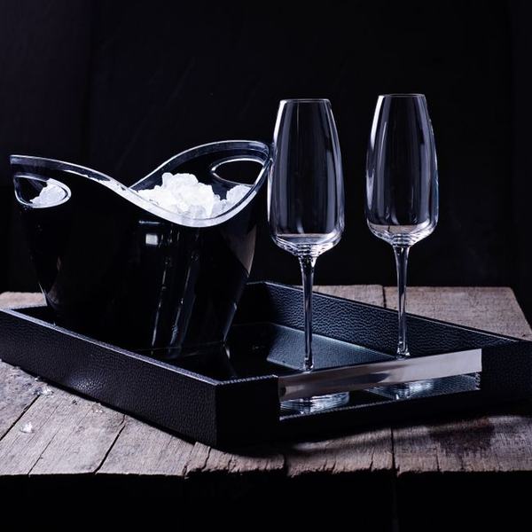 Champagne flutes and an ice bucket on a black tray