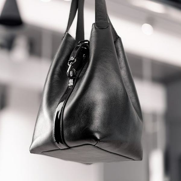 A black leather bag photographed close in low light