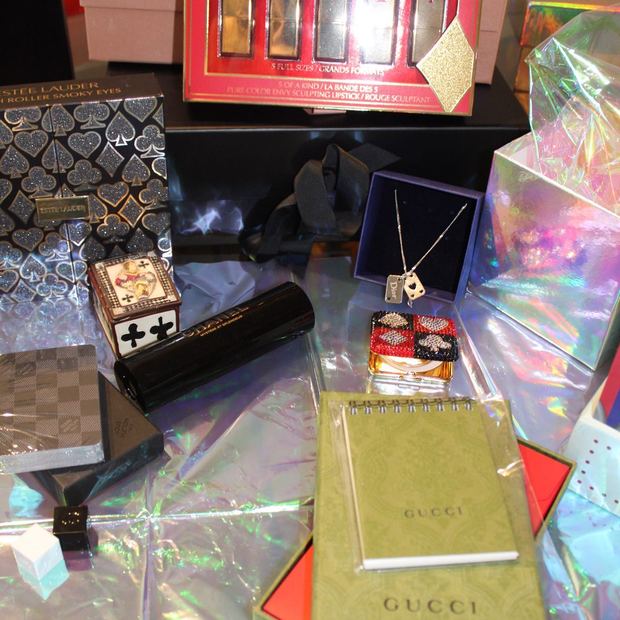A card-themed luxury gift spread with Estee Lauder, Chanel, Louis Vuitton, Gucci and a Dior necklace