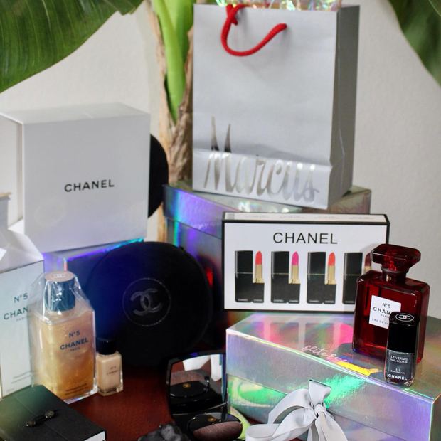 Chanel No.5 perfume, lipstick set, compacts and a silk eye mask arranged with a personalised gift bag and an iridescent Elite Eye box
